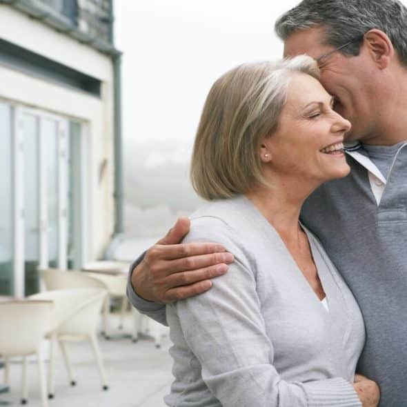 A mature couple hugging outdoors