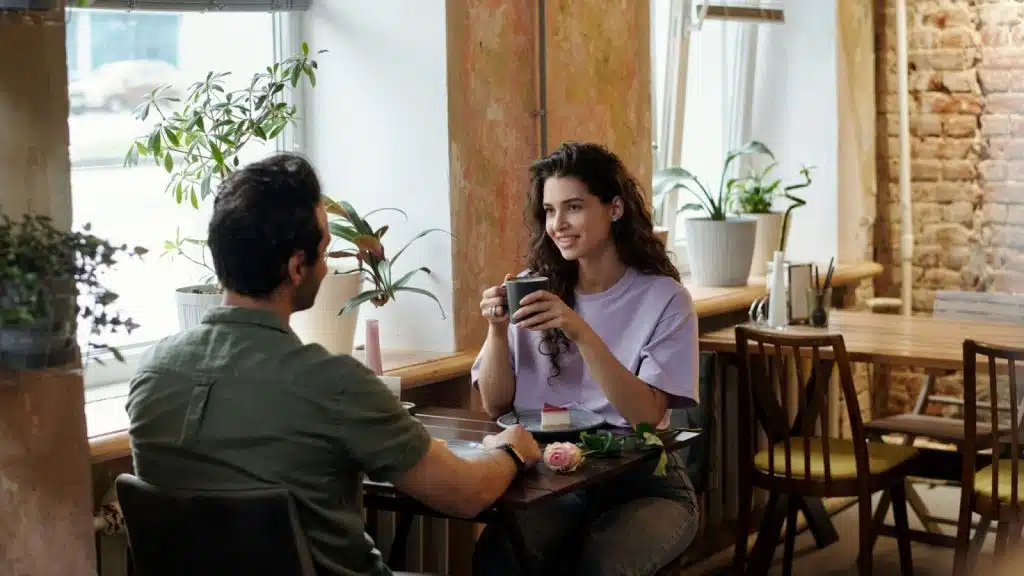 A man and woman at the restaurant and talking.
