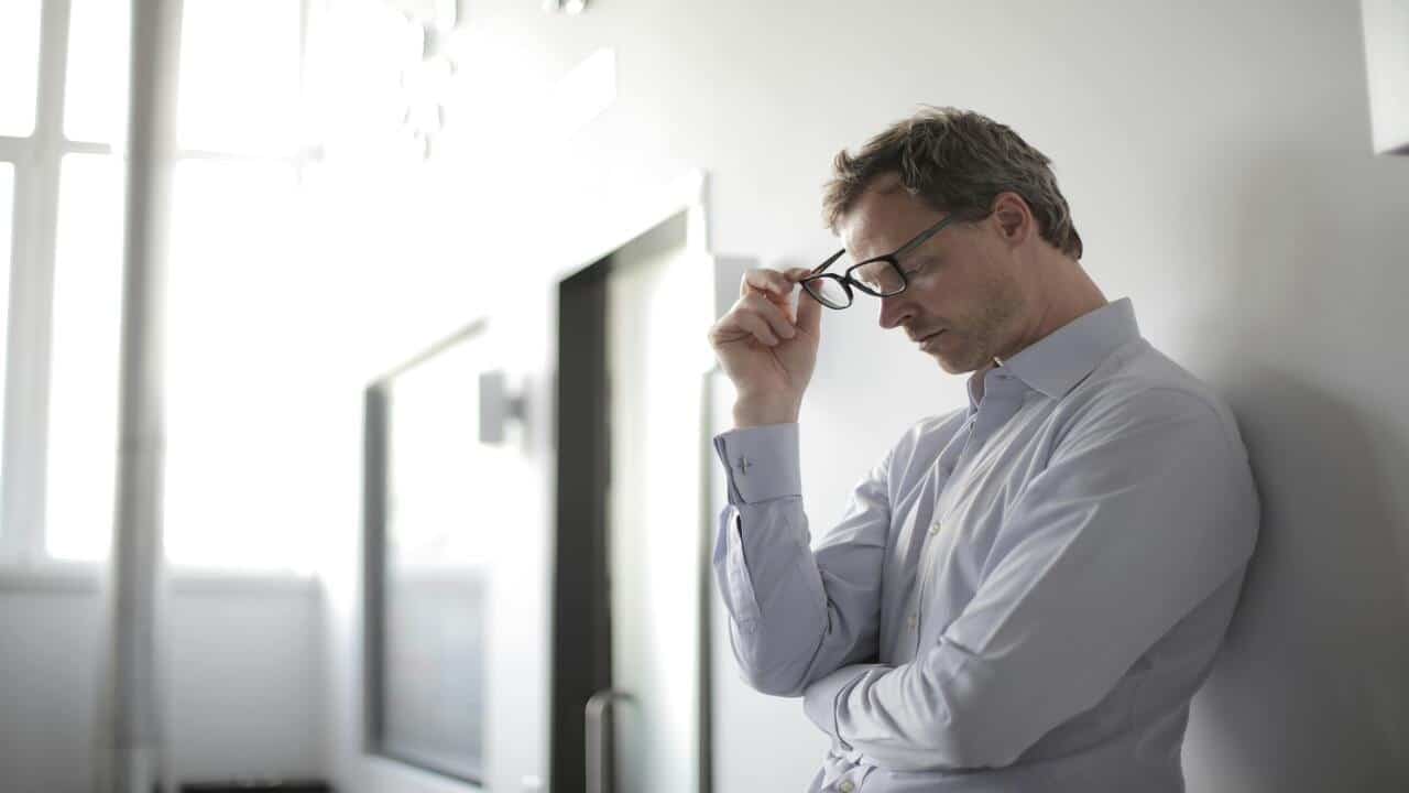 A man looking upset at a hallway