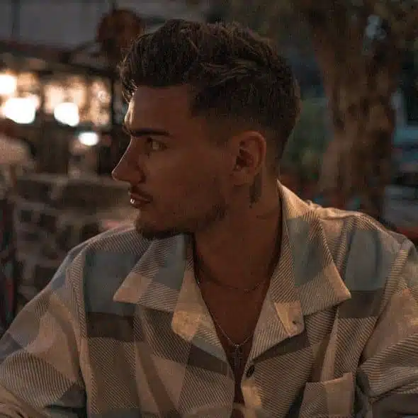 A man sitting at a table outside.