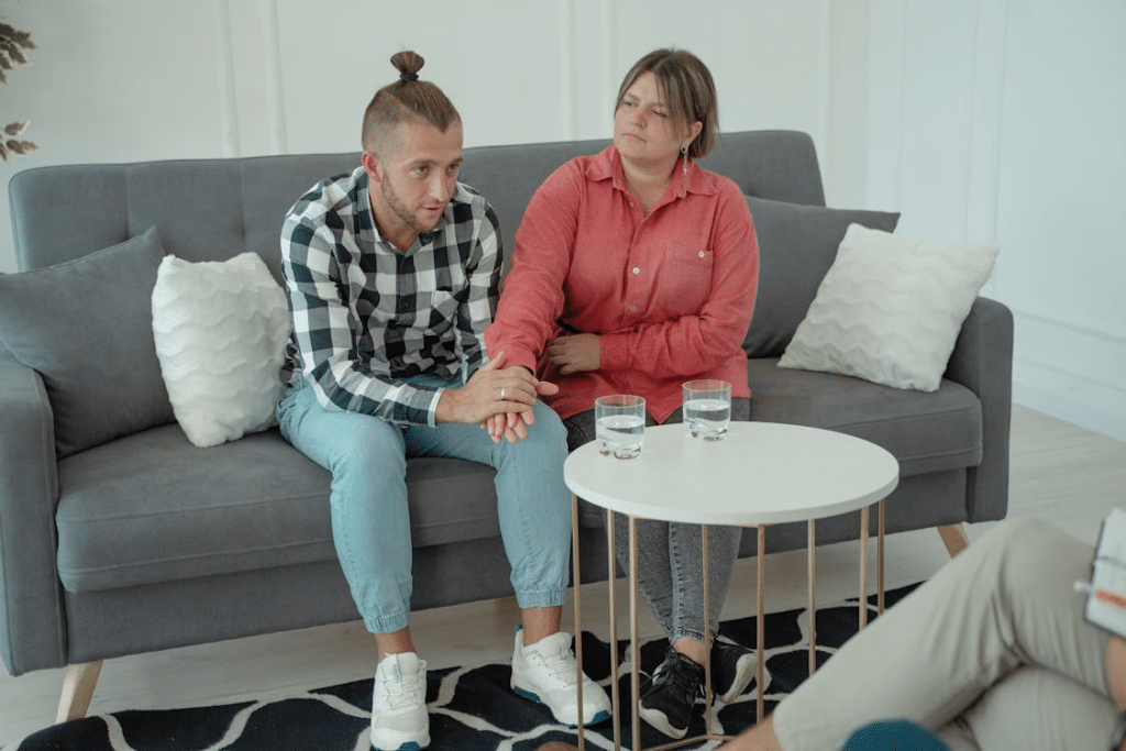 Man not moving on couch beside wife
