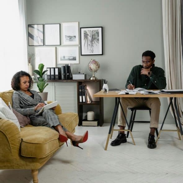 A man and woman in the same room but not talking to each other