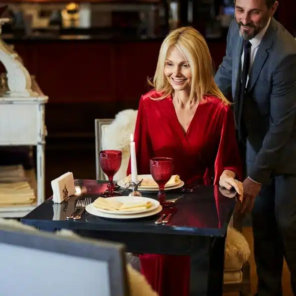 A well-mannered man on a date with a woman wearing a red dress