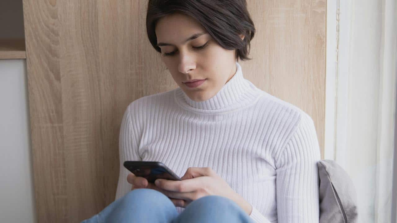 A woman looks down at her phone.