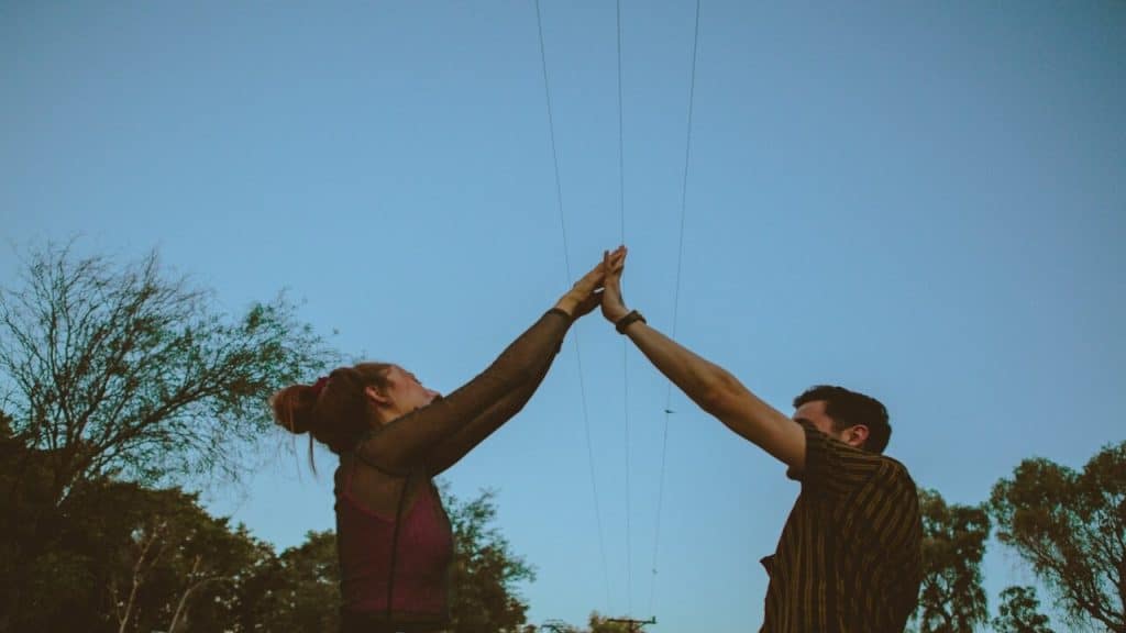A couple high-fiving outdoors