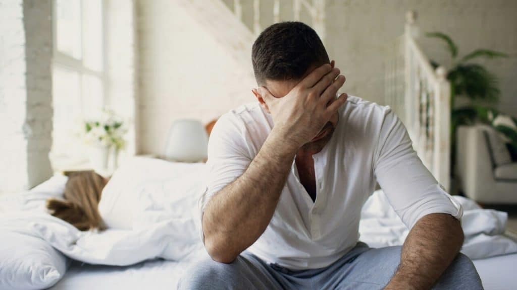 A man looking sad in the bedroom