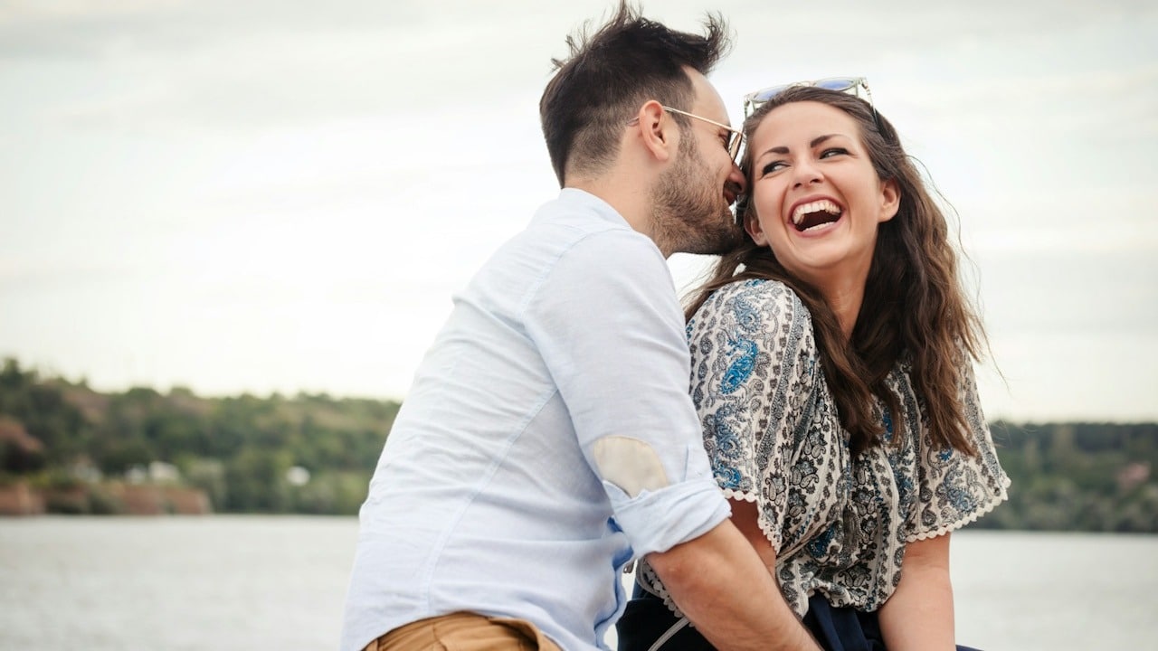 Happy beautiful couple in love smiling and laughing outdoors.