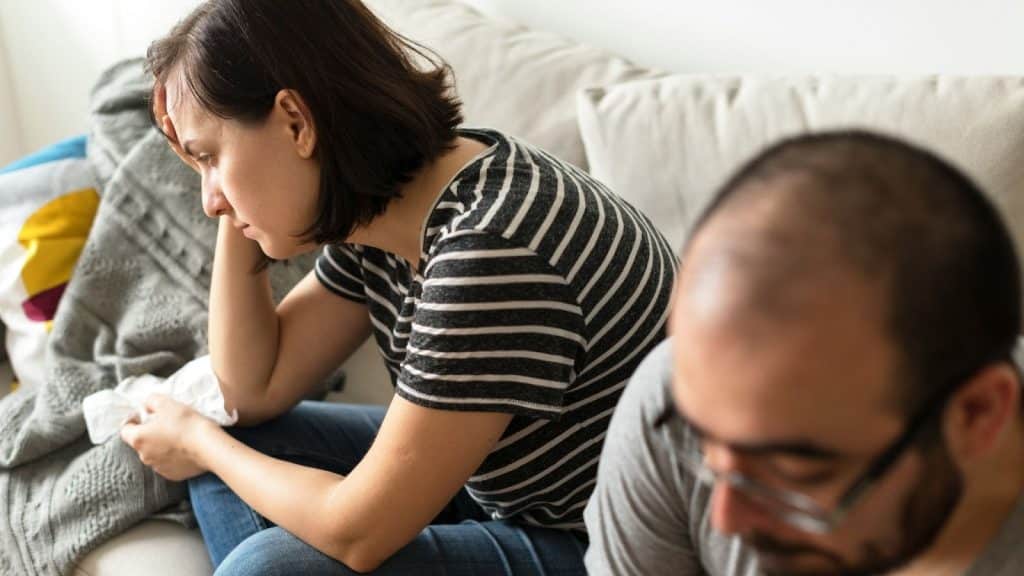 A woman stressed and a man ignoring her