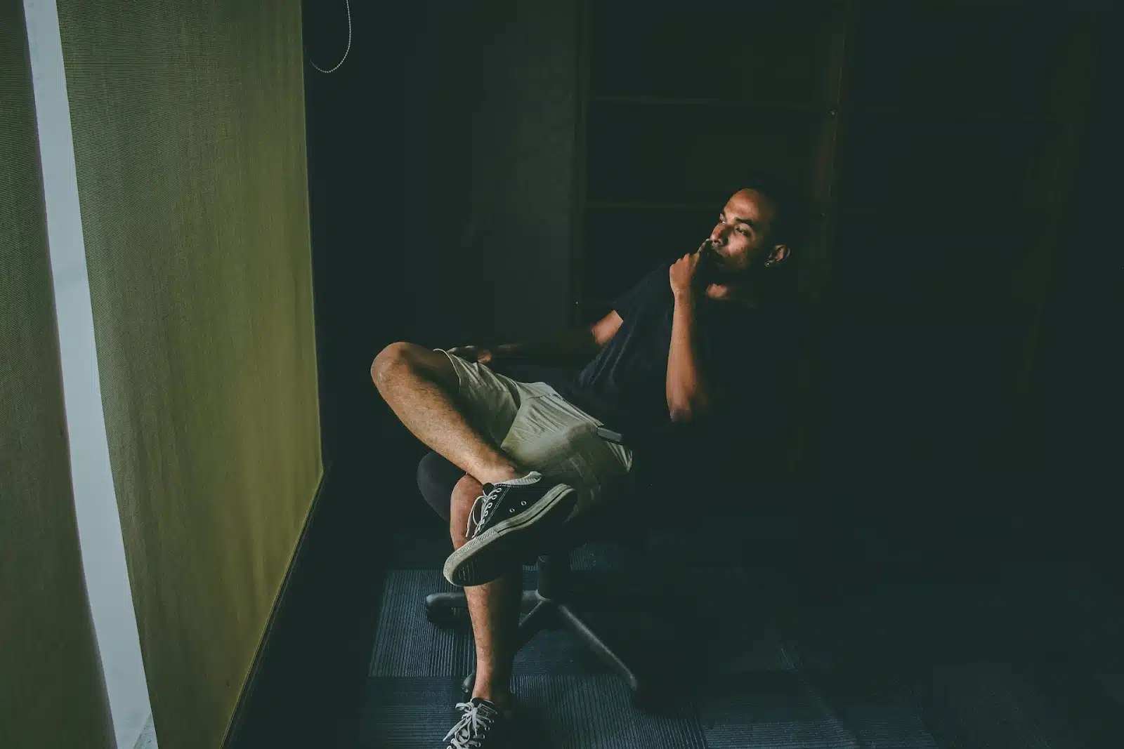 A male sitting by the window and reflecting