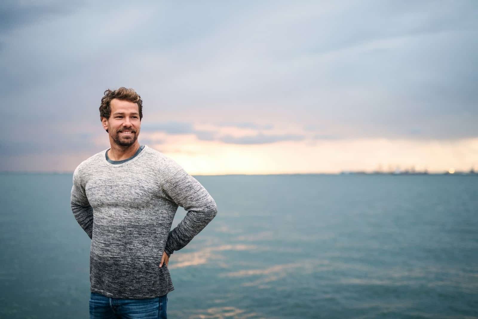 A man in a calm hopeful expression outdoors