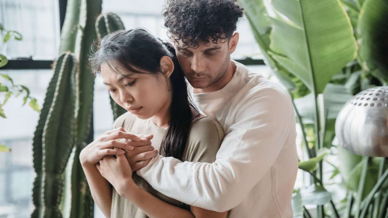 A couple hugging by the window