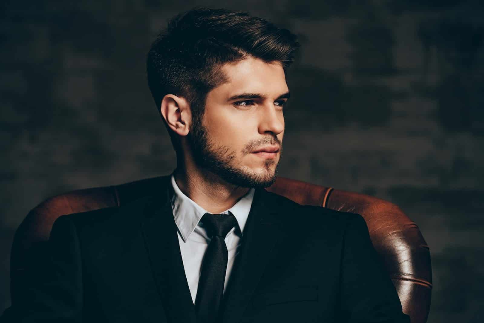 A man in a suit looking at his side