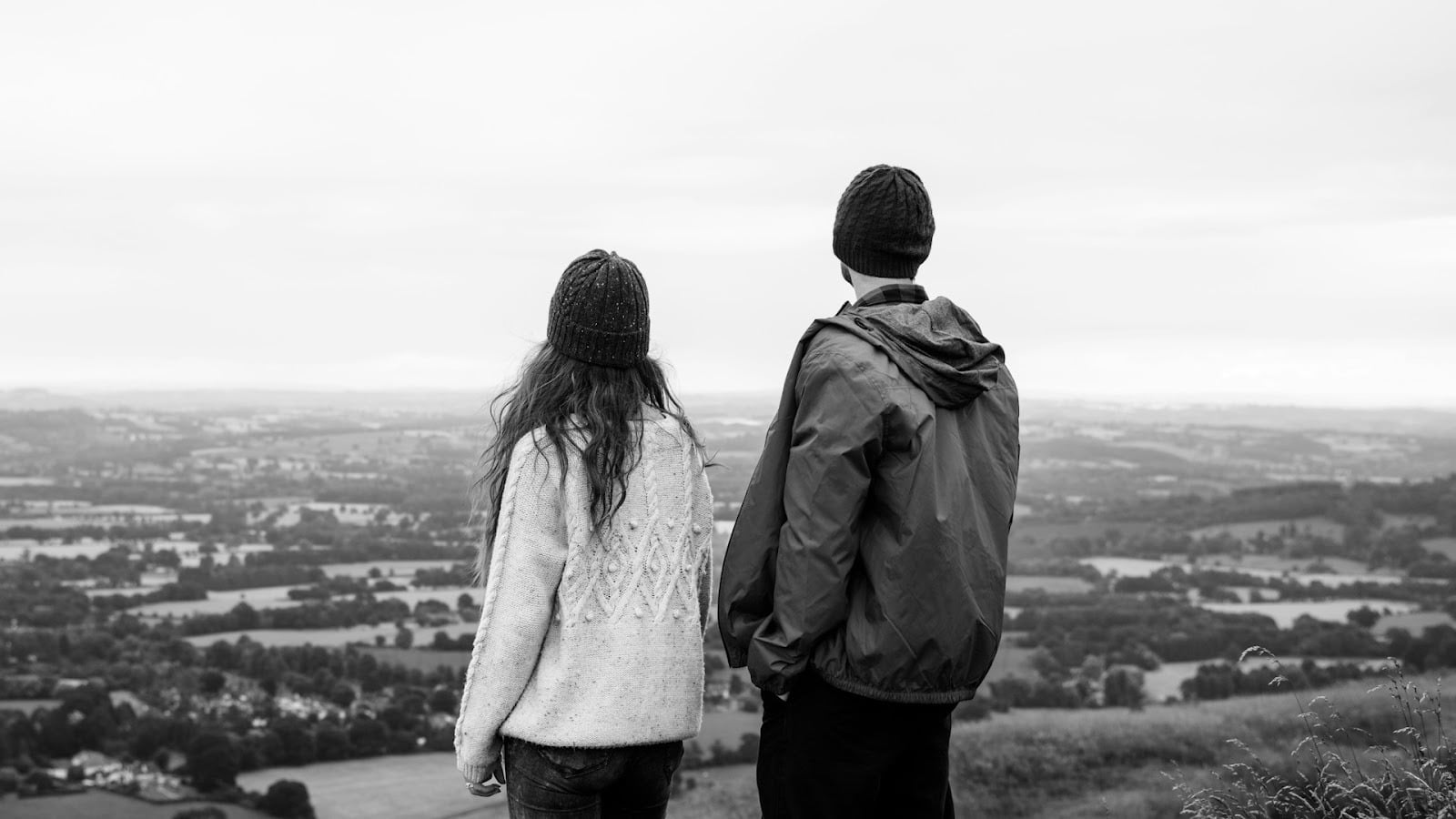 A black and white photo of couple looking at a scenery