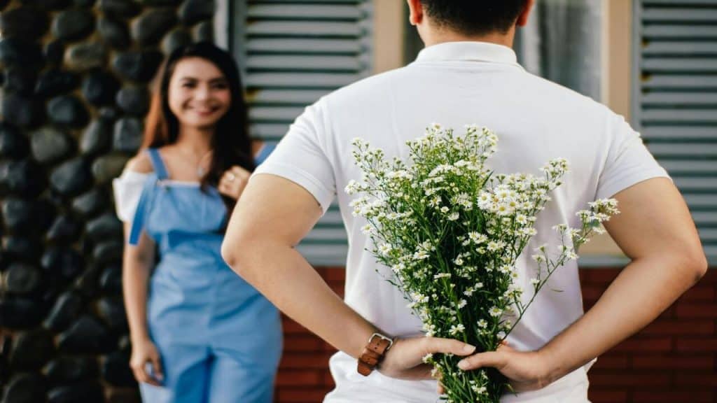 A man surprising his wife with flowers