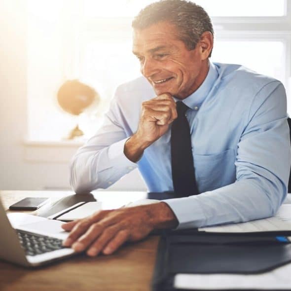 A man smiling at his work desk