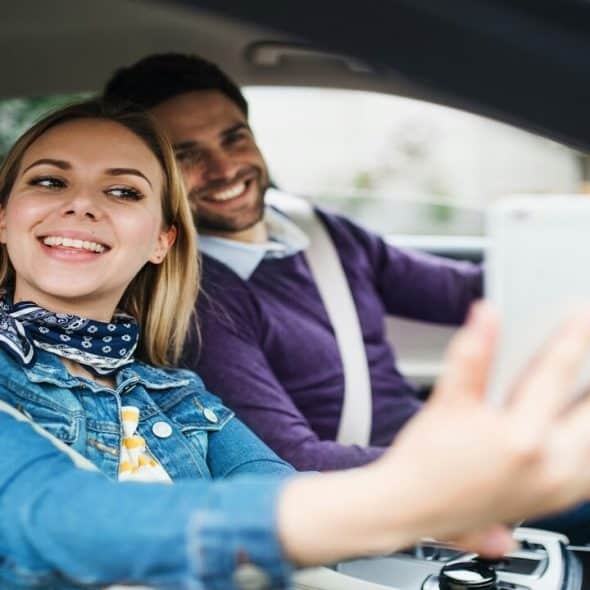 A couple taking a selfie in the car
