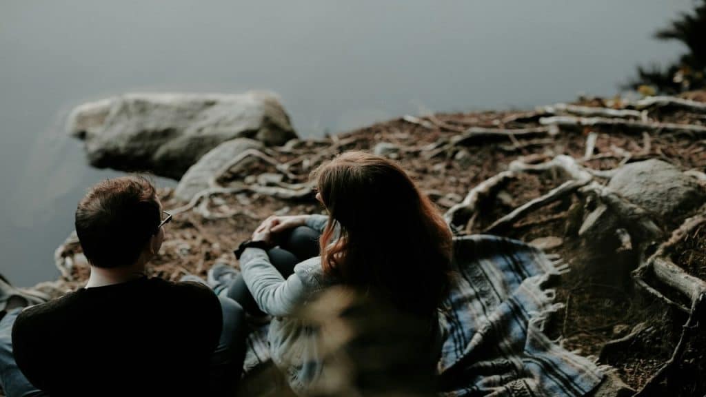 A couple sitting by a body of water
