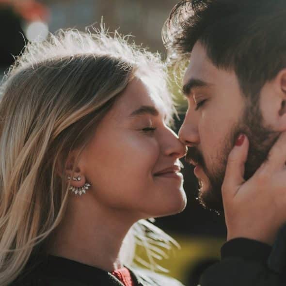 A couple smiling and about to kiss.