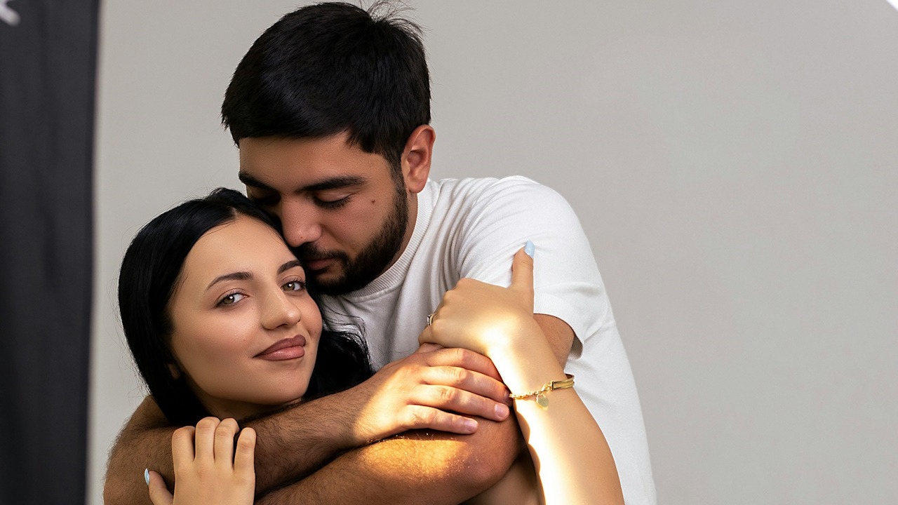 A loving couple embraces each other affectionately.