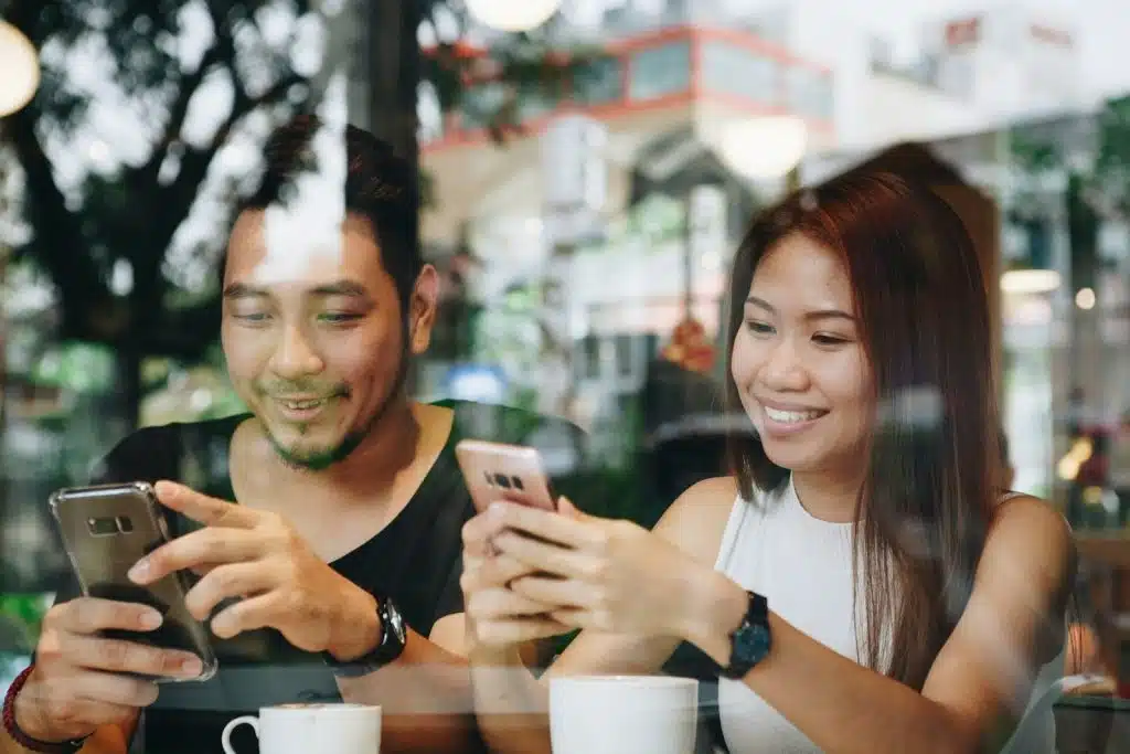 couple texting in coffee shop