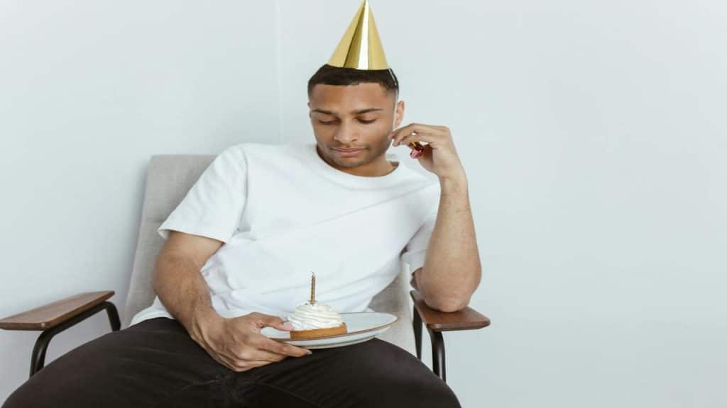 A man looking sadly at his cake