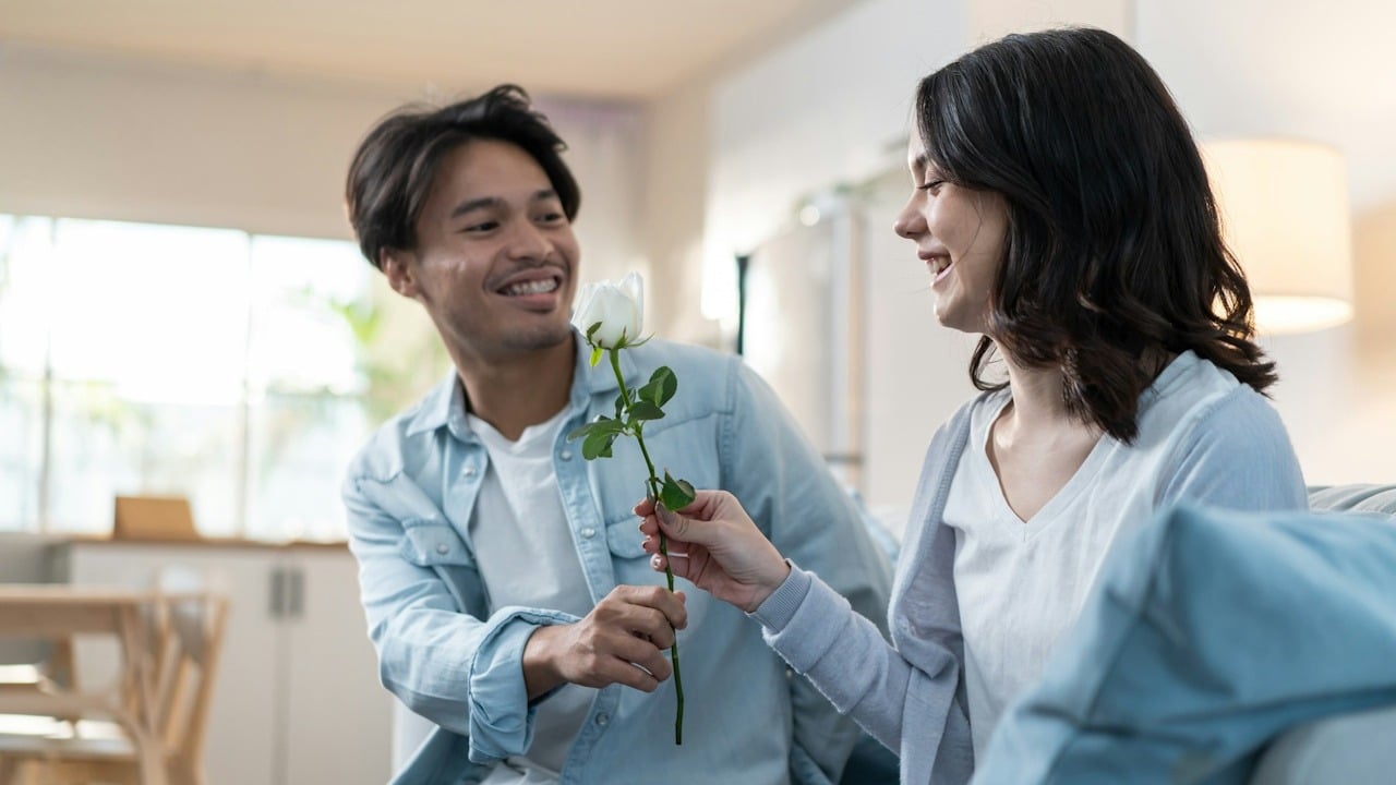 A young man and woman spend time together in the living room at home, celebrating their anniversary in the house.