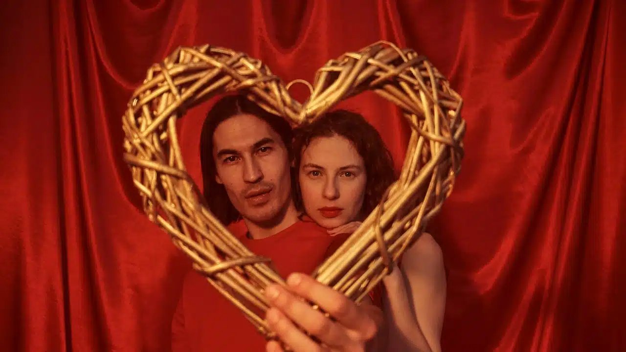 A man and woman holding a heart shaped basket.