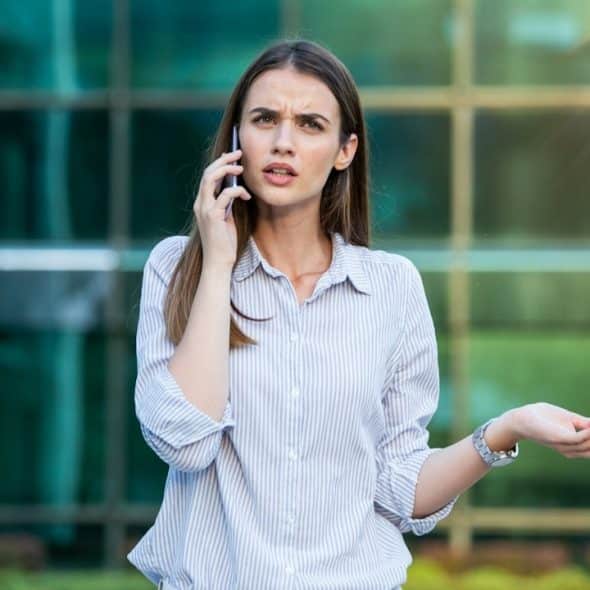 Woman in informal wear having trouble with contracts talking on the phone.