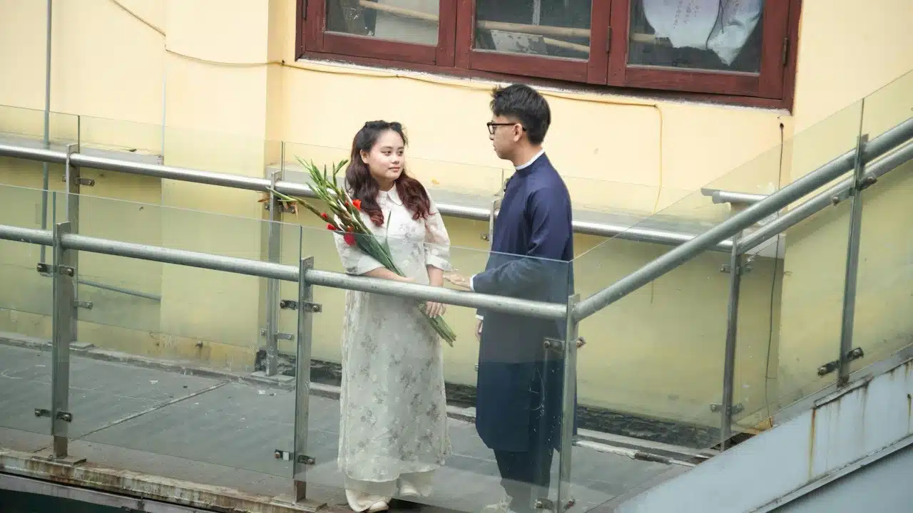 A man and a woman standing on a balcony.