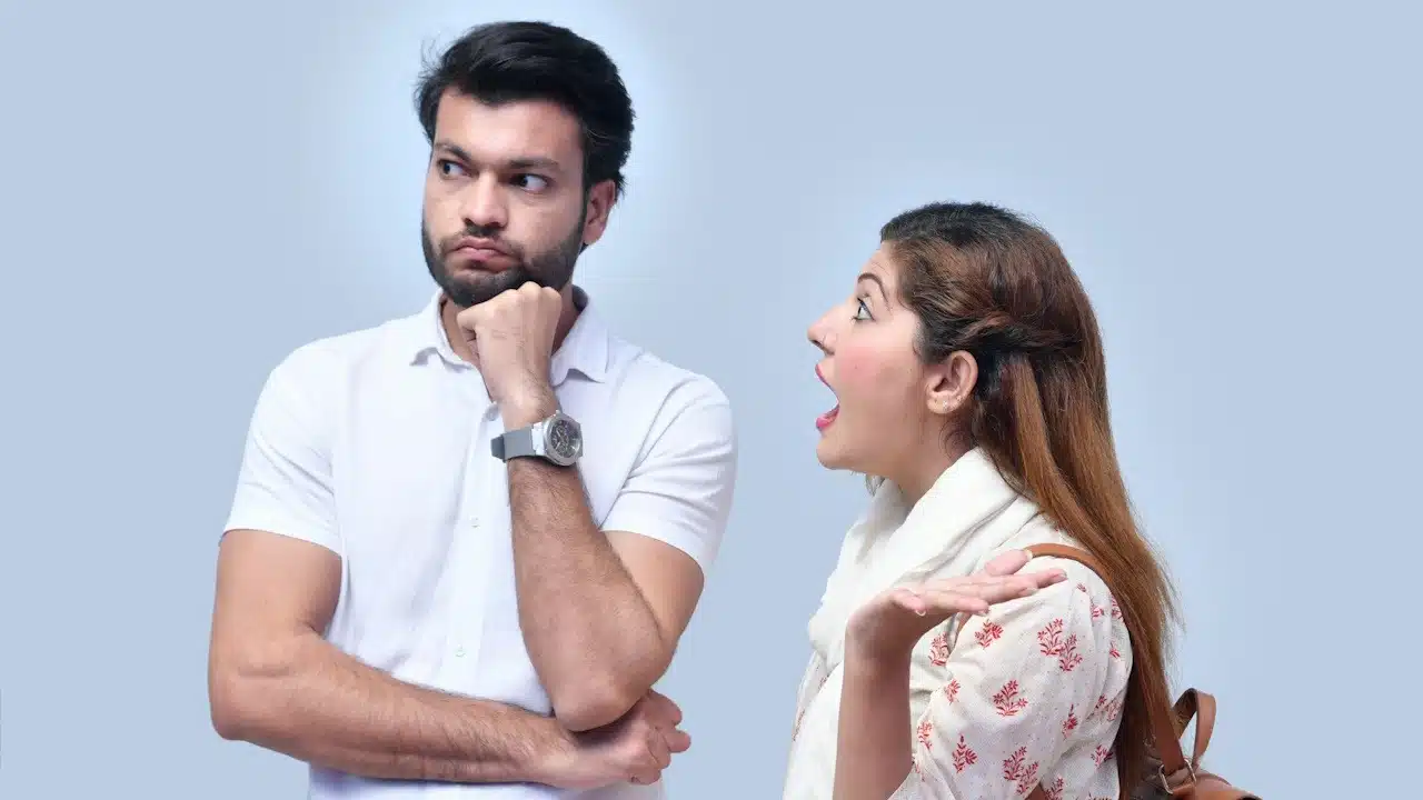 A woman shouting at her husband who is looking away.