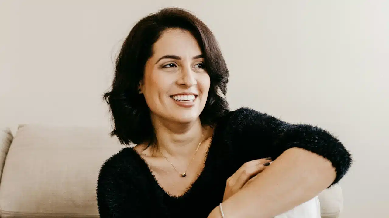 A woman smiling and looking to the side.