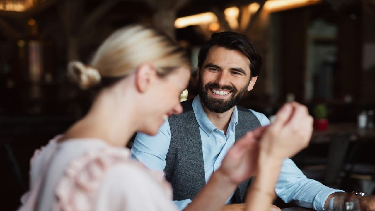 A man and a woman laughing at a restaurant