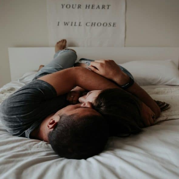 A couple cuddling in bed