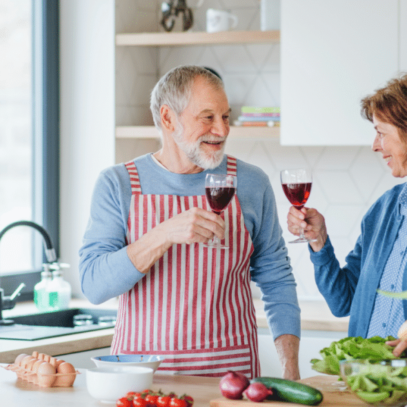A couple clinking glasses in the kitchen