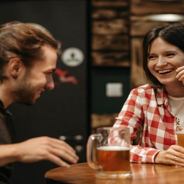 A couple laughing while drinking beer