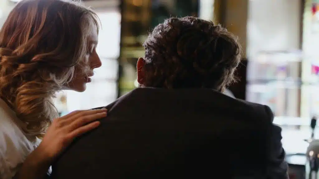 A woman touching a man’s shoulder