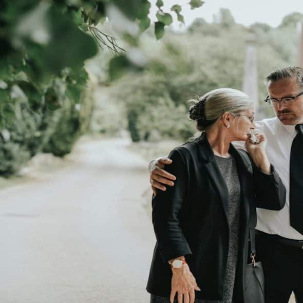 A man comforting his grieving wife