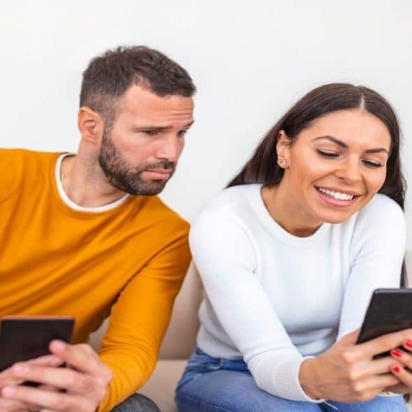 A man looking at who his wife is texting