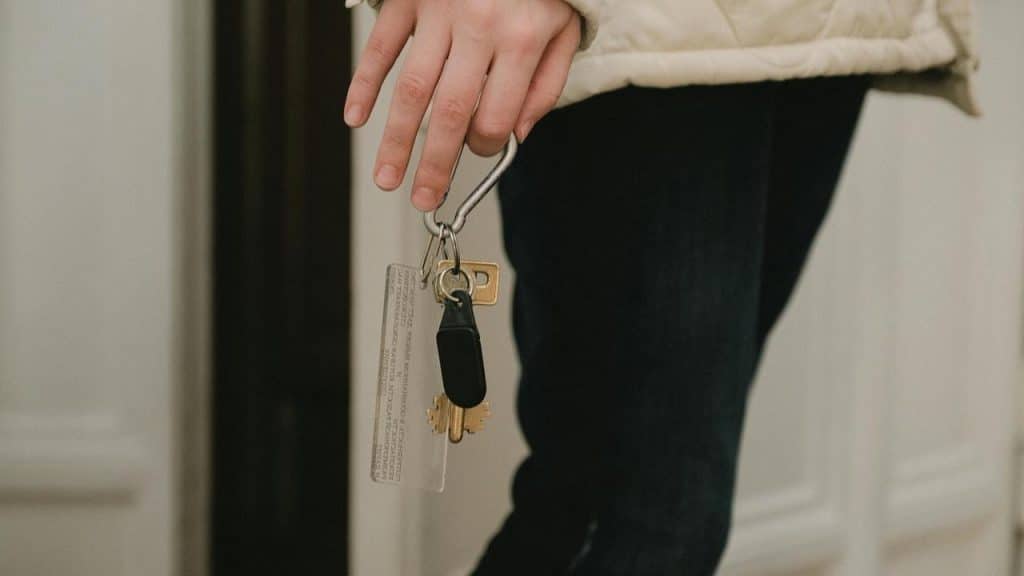 A person holding a keyring with several keys.