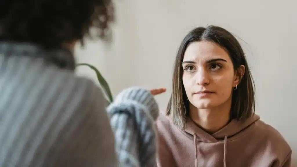 A woman listening seriously during a conversation indoors.