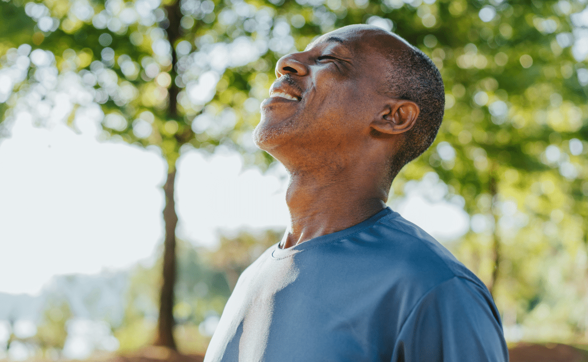 A man taking a deep breath outdoors
