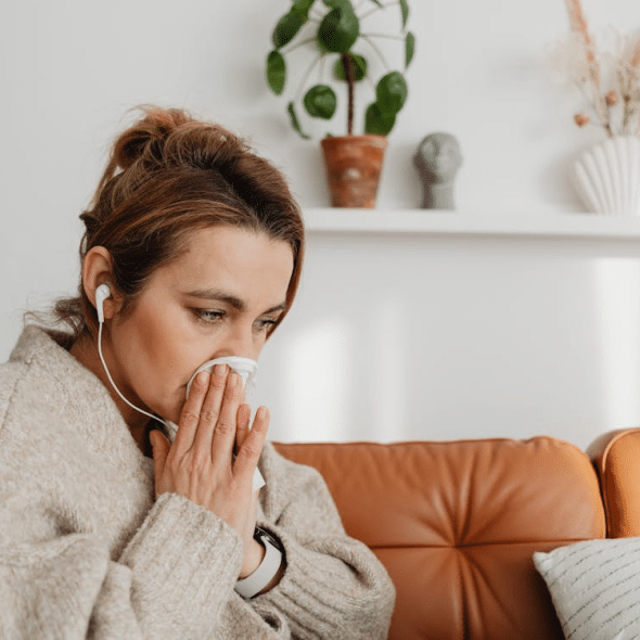 Upset woman sitting on couch listening to music