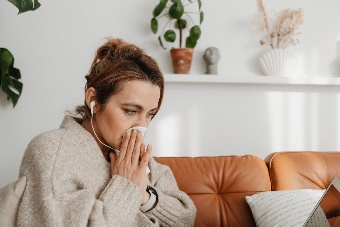 Upset woman sitting on couch listening to music