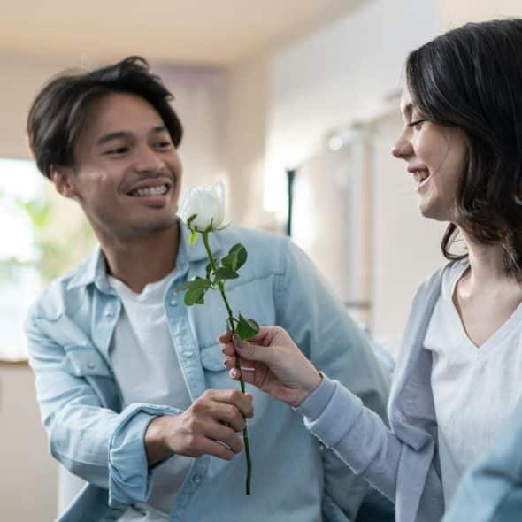 A young man and woman spend time together in the living room at home, celebrating their anniversary in the house.