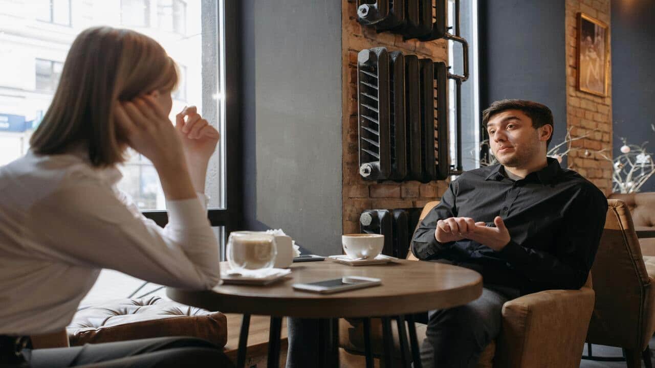 A couple talking at a coffee shop