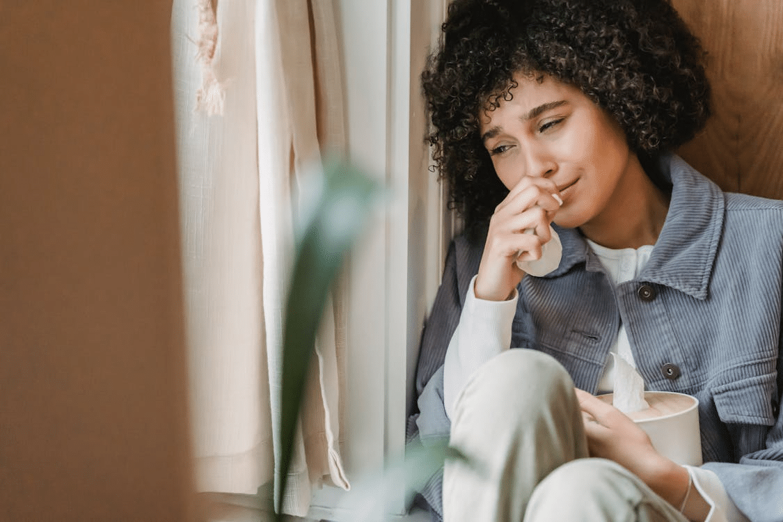 Woman crying sitting on windowsill