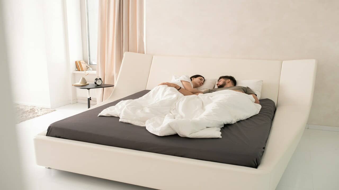 A couple looking at each other in bed
