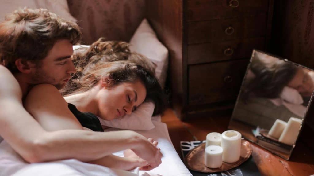 A man looking at his sleeping wife 