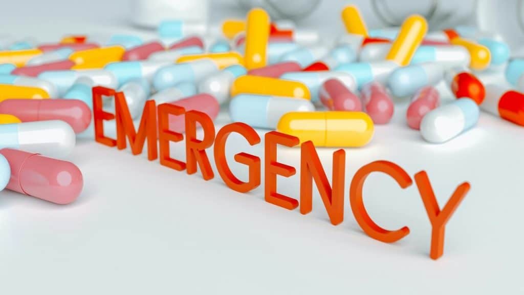 The word “emergency” surrounded by pills