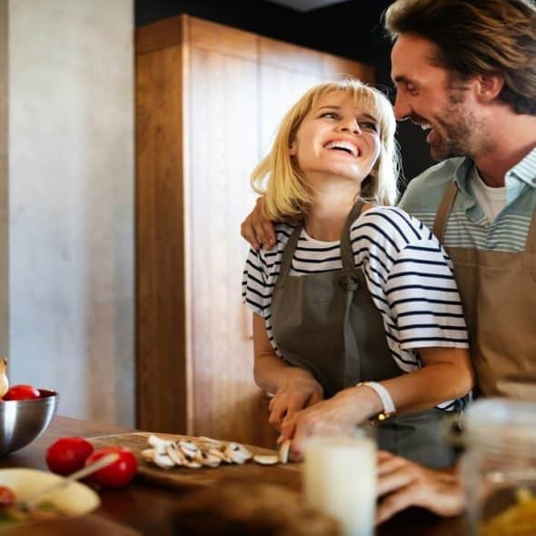 A couple laughing in the kitchen